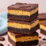A stack of three Buckeye brownies on a light pink surface.