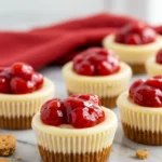 Cheesecake cupcakes on a white marble surface and a red napkin in the background.