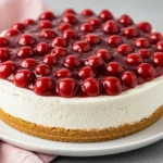 Cherry cheesecake on a big white plate.