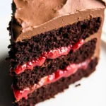 A slice of Chocolate Cake with Strawberries sits on a white plate.