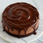 Chocolate mousse cake on flat white marble plate.