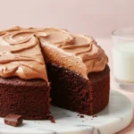 Chocolate Nutella cake with a slice missing on a white marble plate.