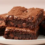 Cottage Cheese Brownies on a white plate against light pink surface.