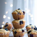 Stack of cottage cheese blueberry muffins on a white marble surface.