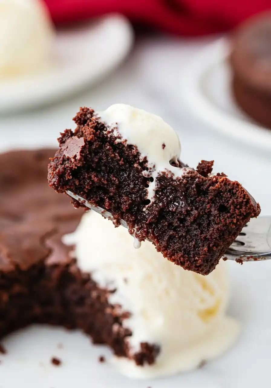 A fork holds a serving of flourless chocolate cake.