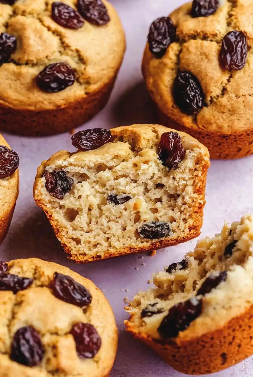 gabs raisin muffins, with one split in half, showing the soft interior.