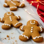 Gingerbread cookies on a marble surface and a red napkin nearby.