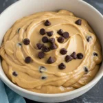 Greek yogurt cookie dough in a white bowl against a marble surface.