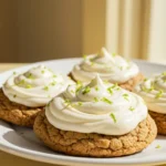 Key lime cookies placed on a white plate against a light-yellow surface.