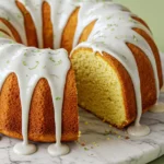 Key lime pound cake on a white marble flat plate with a slice missing.