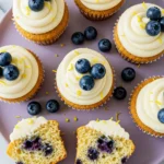Lemon blueberry cupcakes on a light purple plate and one of them split in half.