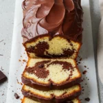 Marble cake on parchment paper and some slices cut from it.