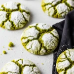 Matcha crinkle cookies on a light gray surface.