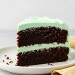 A big slice of mint chocolate cake on a white plate.