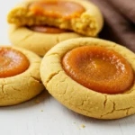 Pumpkin pie cookies on a white wood surface.