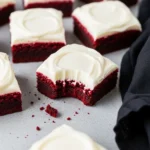 Red velvet brownies and one of them has a bite missing.