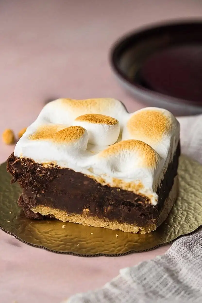 S'mores Brownie placed on golden plate against light pink surface