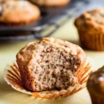 Sourdough Banana Muffin places on a light-yellow surface.