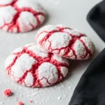 Strawberry crinkle cookies on a light gray surface.