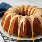 Sweet potato pound cake on a black rack and drizzled with maple glaze.