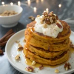 Sweet potato pancakes on a white plate against a dark marble surface.