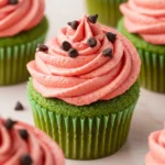 Watermelon cupcakes placed on a light pink surface.