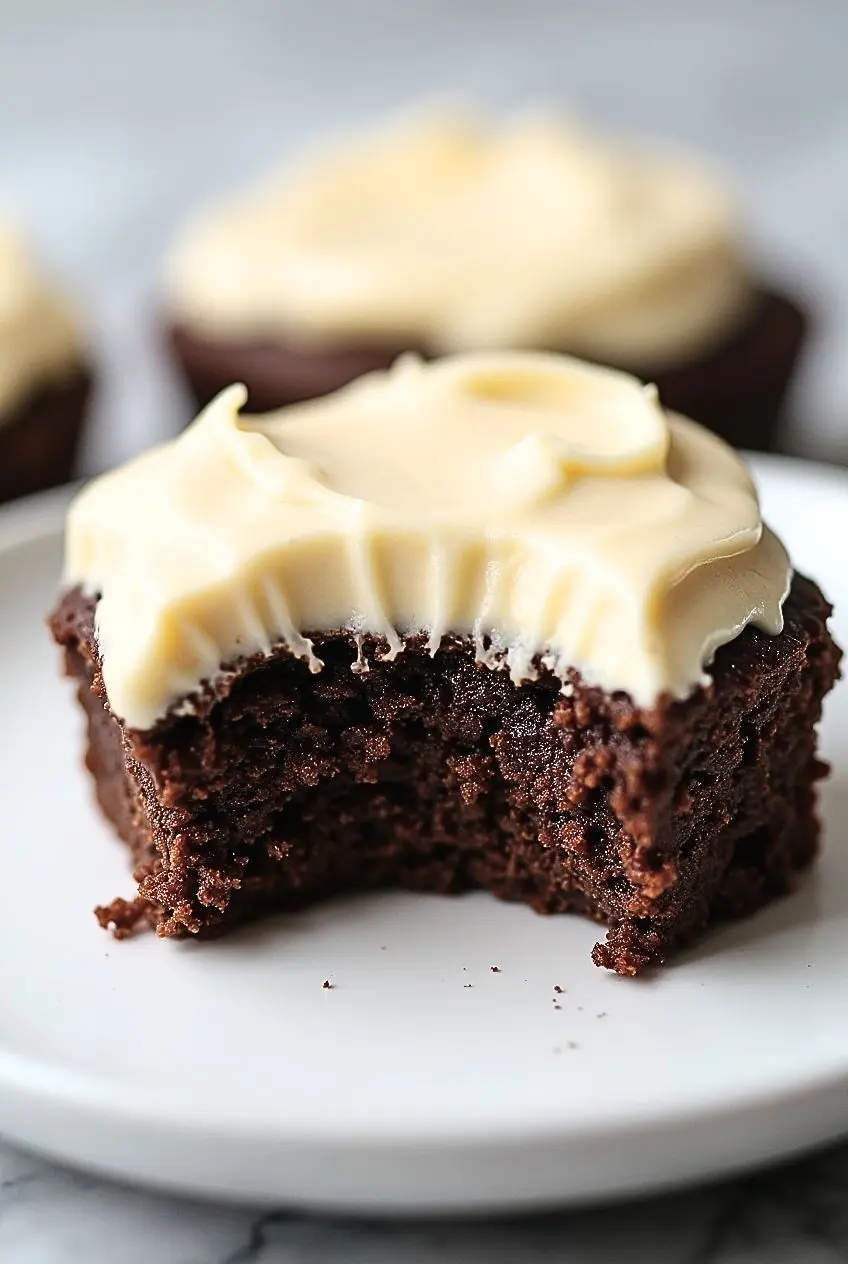 brownie with cream cheese frosting has a bite taken out of it.