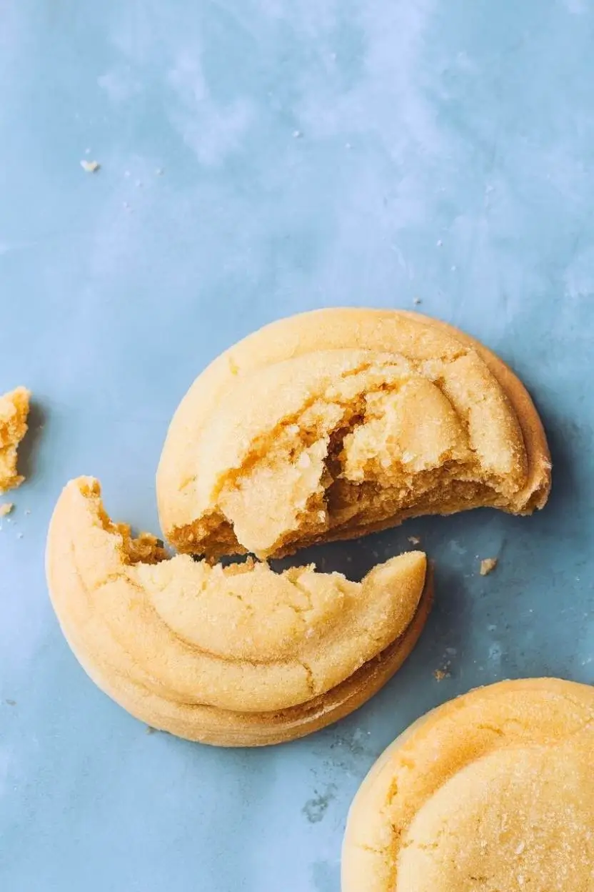 Sourdough sugar cookie split in half and placed on a light blue surface.