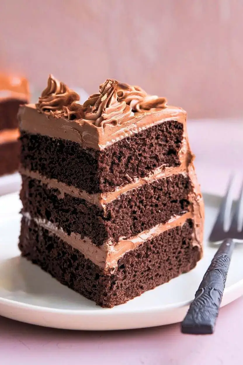 Slice of Swiss chocolate chalet cake with a fork next to it